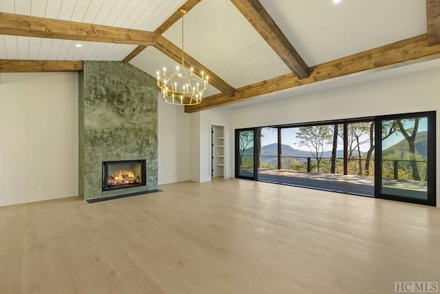 unfurnished living room with a fireplace, plenty of natural light, beam ceiling, and a mountain view