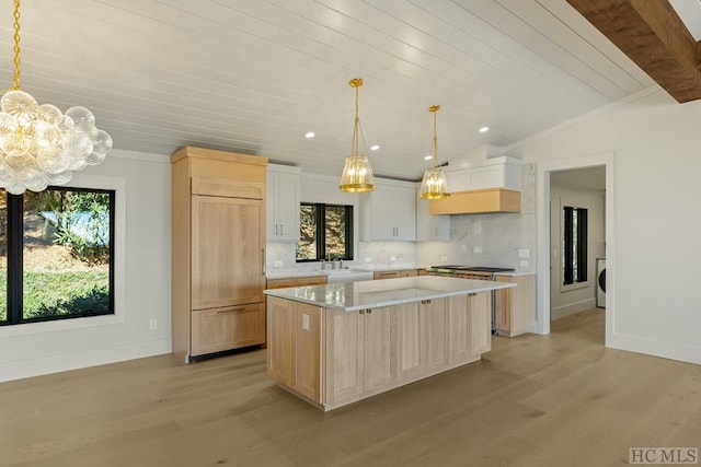 kitchen featuring paneled built in fridge, light hardwood / wood-style floors, white cabinets, a kitchen island, and light brown cabinetry