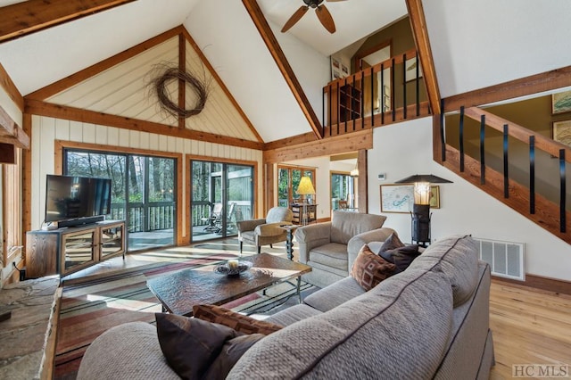 living room with light hardwood / wood-style flooring, high vaulted ceiling, and ceiling fan