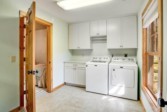 washroom featuring separate washer and dryer and cabinets