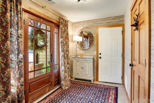 entryway featuring a textured ceiling and wood walls