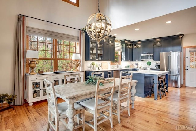 dining room with a notable chandelier, light wood-type flooring, and a wealth of natural light