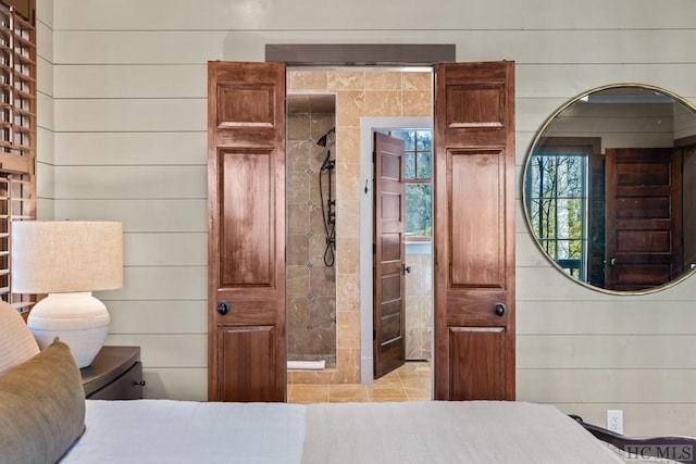 bedroom featuring multiple windows and wood walls