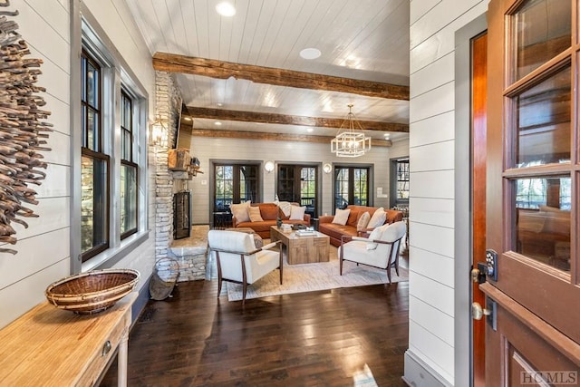 living room featuring wood ceiling, a chandelier, wooden walls, dark hardwood / wood-style floors, and beamed ceiling