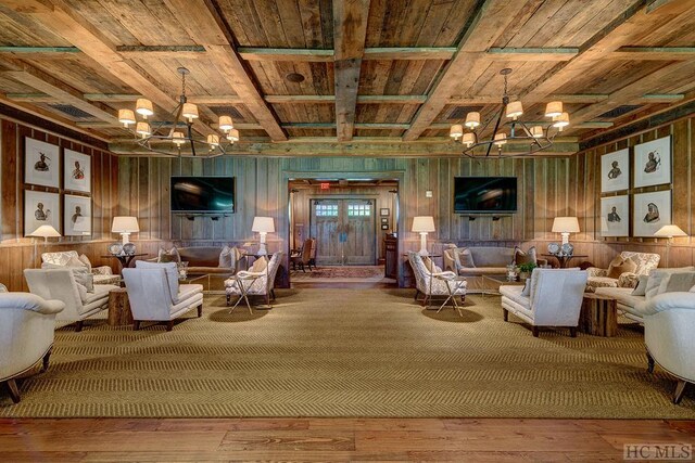 living room featuring an inviting chandelier, beam ceiling, hardwood / wood-style floors, and wooden ceiling