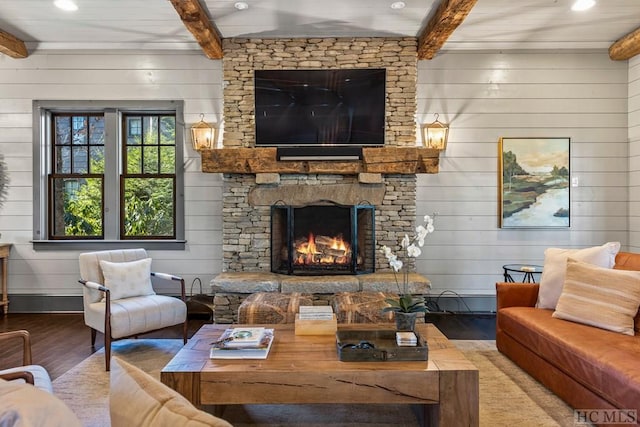 living room with beamed ceiling, a fireplace, hardwood / wood-style floors, and wood walls