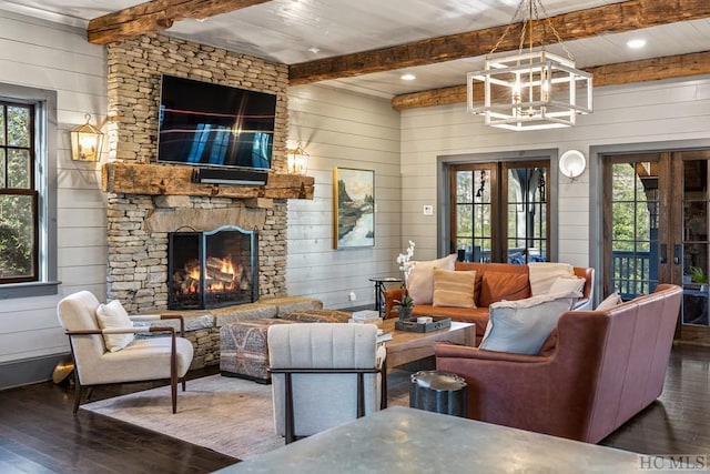 living room featuring beam ceiling, dark hardwood / wood-style flooring, a fireplace, and wooden walls