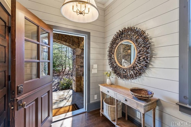 entryway featuring dark hardwood / wood-style flooring and wood walls