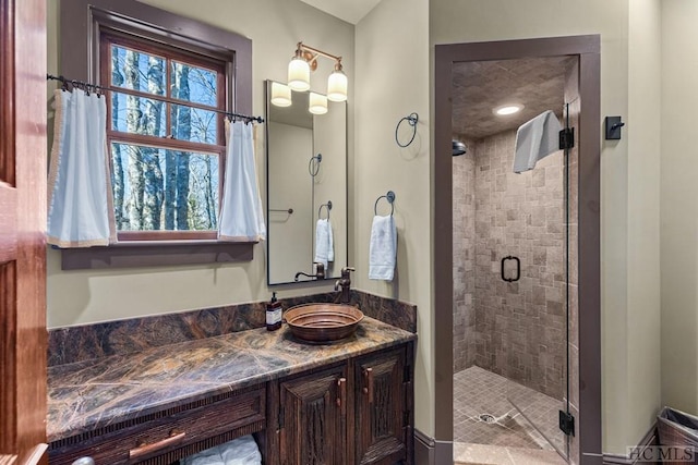 bathroom featuring an enclosed shower, vanity, and plenty of natural light