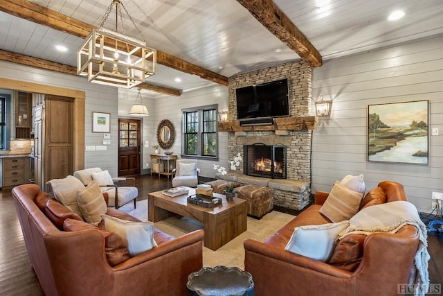 living room featuring wood-type flooring, a stone fireplace, beam ceiling, and wood walls