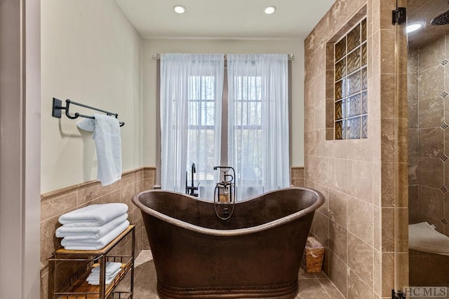 bathroom with tile walls, tile patterned floors, and plus walk in shower