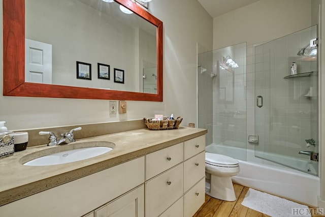 full bath with shower / tub combination, toilet, vanity, and wood finished floors