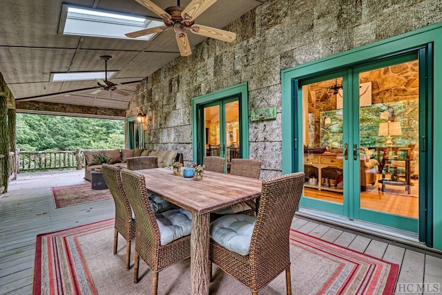 deck featuring outdoor dining space, french doors, and ceiling fan