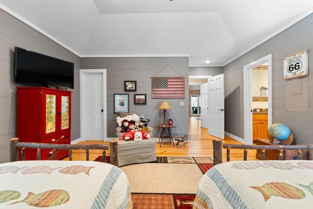 bedroom featuring light wood-style flooring, ensuite bathroom, and vaulted ceiling