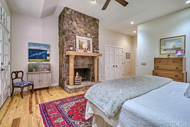 bedroom featuring light wood-style flooring, a ceiling fan, recessed lighting, a fireplace, and vaulted ceiling