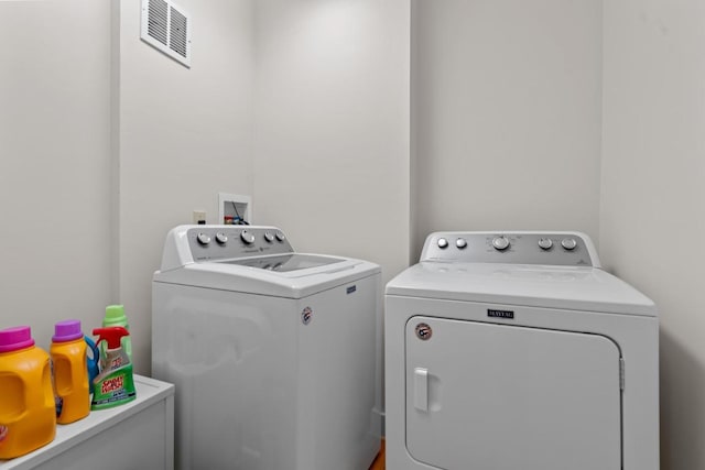 laundry room featuring laundry area, separate washer and dryer, and visible vents