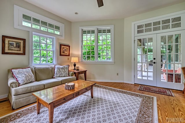 living area with french doors, baseboards, and wood finished floors