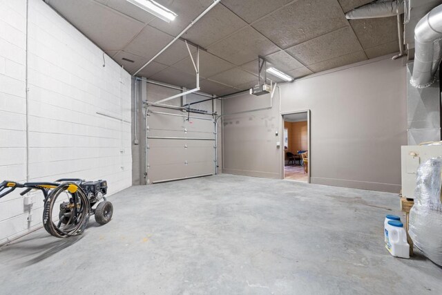 garage with a garage door opener and concrete block wall