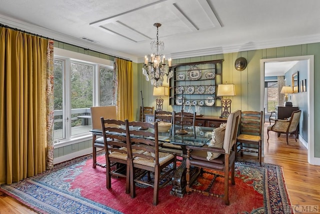 dining space with a wealth of natural light, crown molding, and hardwood / wood-style floors