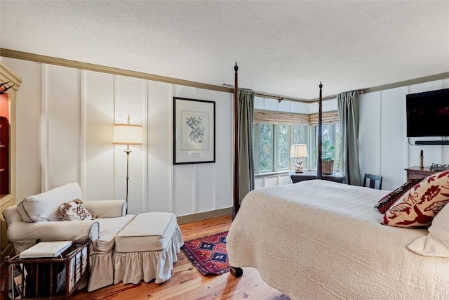 521 Azalea Ln, Cashiers, NC 28717 - bedroom with wood finished floors, a decorative wall, ornamental molding, and a textured ceiling