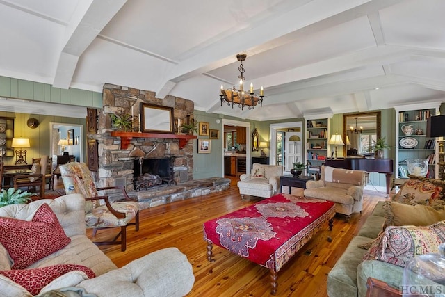 living room featuring an inviting chandelier, a fireplace, and hardwood / wood-style flooring