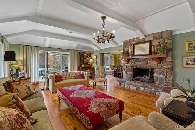 living room featuring wood-type flooring, a fireplace, beamed ceiling, and a notable chandelier