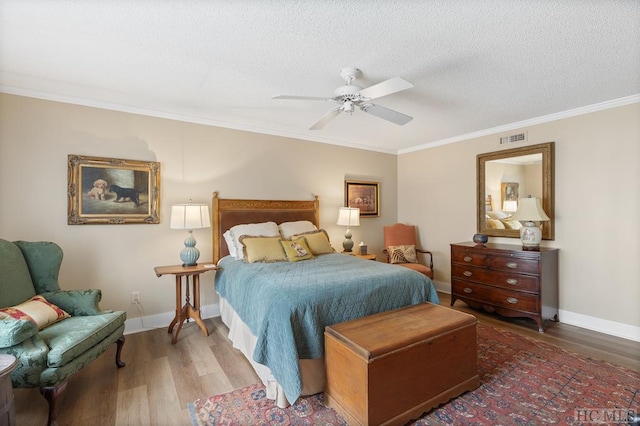 bedroom with ceiling fan, hardwood / wood-style floors, crown molding, and a textured ceiling