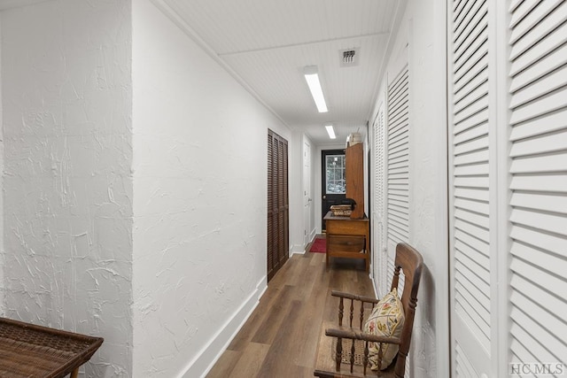 hallway with dark hardwood / wood-style flooring and crown molding