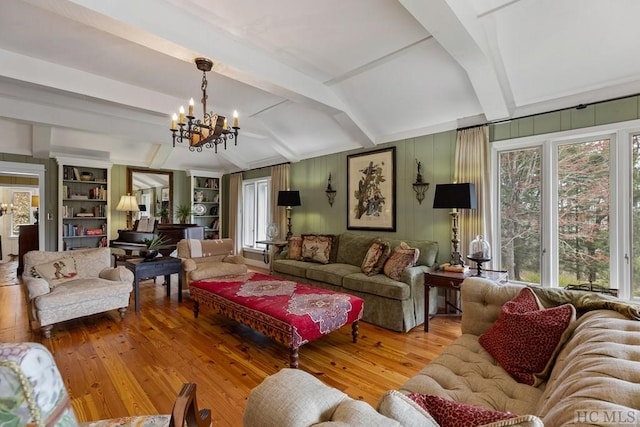 living room with wood-type flooring, built in features, beam ceiling, and an inviting chandelier