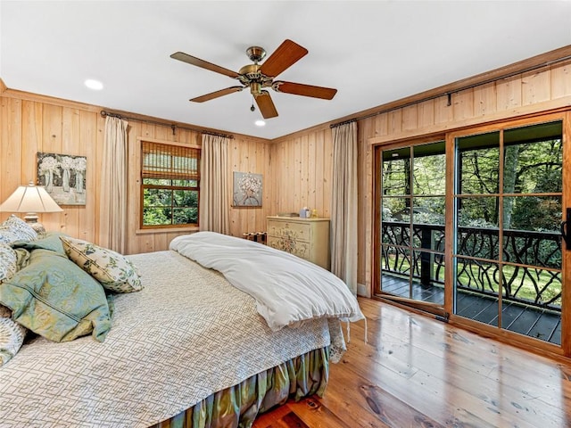145 Island Point Rd, Lake Toxaway, NC 28747 - bedroom with access to exterior, multiple windows, wooden walls, hardwood / wood-style flooring, and ceiling fan