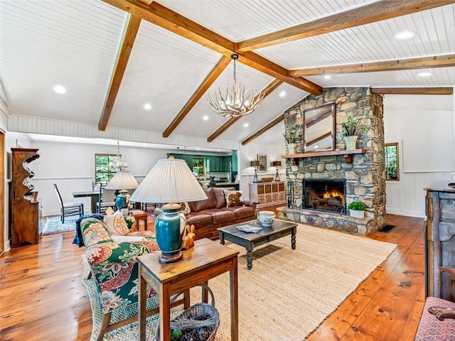145 Island Point Rd, Lake Toxaway, NC 28747 - living area featuring hardwood / wood-style floors, wainscoting, a chandelier, a stone fireplace, and plenty of natural light