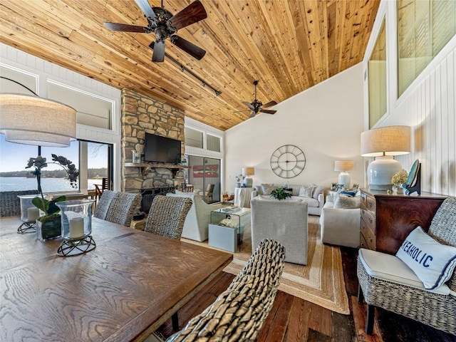 dining room with a water view, wooden ceiling, hardwood / wood-style flooring, ceiling fan, and a fireplace