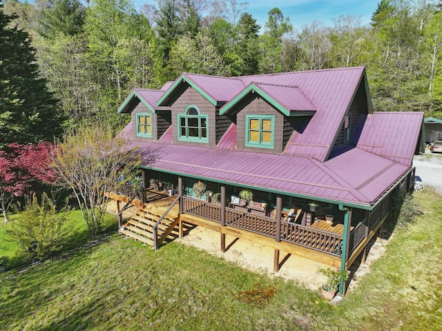view of front of property with a front lawn, covered porch, and metal roof
