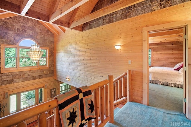 hallway with wood ceiling, wooden walls, high vaulted ceiling, and beamed ceiling