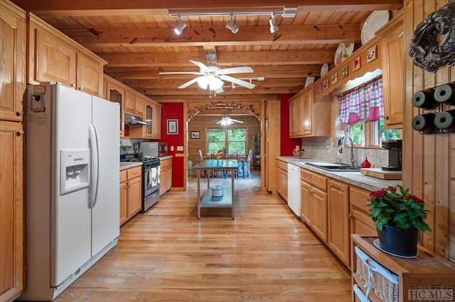 kitchen featuring beamed ceiling, a healthy amount of sunlight, appliances with stainless steel finishes, and rail lighting