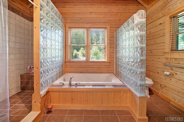 bathroom with toilet, tile patterned flooring, and wood walls