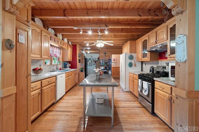 kitchen featuring tasteful backsplash, white appliances, a center island, and sink