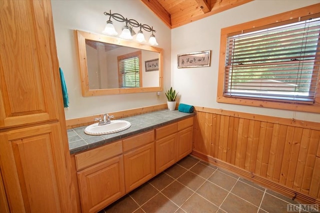 bathroom featuring tile patterned floors, wood ceiling, vaulted ceiling, vanity, and wooden walls