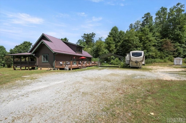 view of home's exterior featuring a carport, a wooden deck, and a storage unit