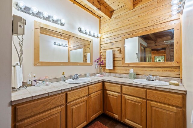 bathroom featuring a sink, wood ceiling, beam ceiling, and wood walls