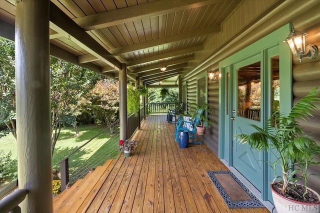 wooden deck with a lawn and covered porch