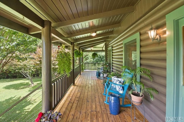 wooden terrace featuring a porch and a lawn