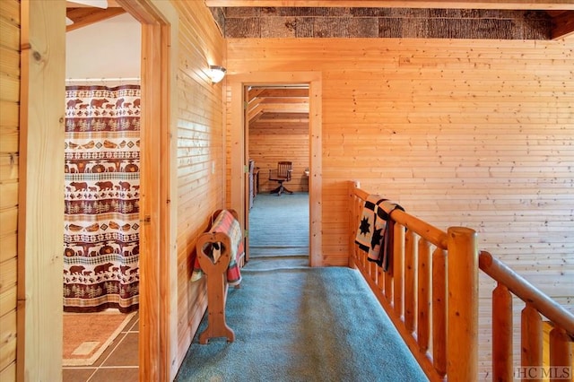 hallway with wooden walls and carpet flooring