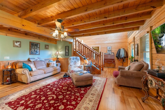 living area featuring stairway, wood walls, beamed ceiling, wood ceiling, and hardwood / wood-style flooring