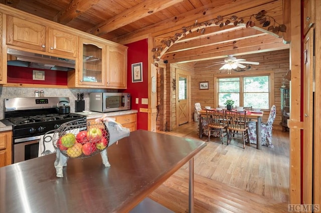 kitchen with appliances with stainless steel finishes, wooden walls, wooden ceiling, beamed ceiling, and light wood-type flooring