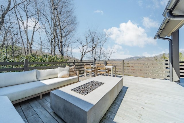 deck featuring an outdoor living space with a fire pit