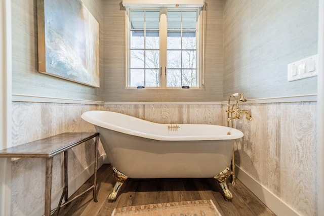 full bath featuring a freestanding tub, wainscoting, and wood finished floors