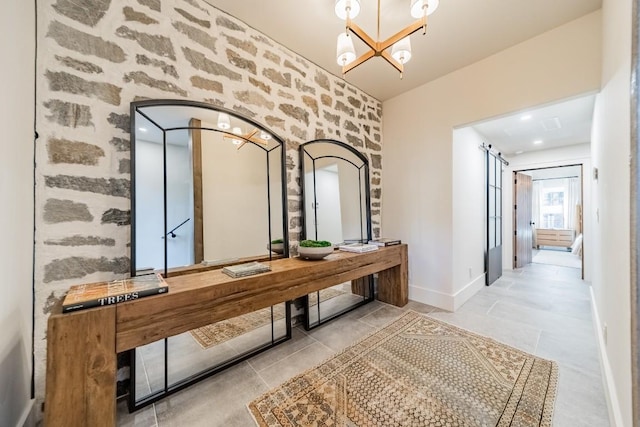 corridor featuring baseboards, a chandelier, and tile patterned floors