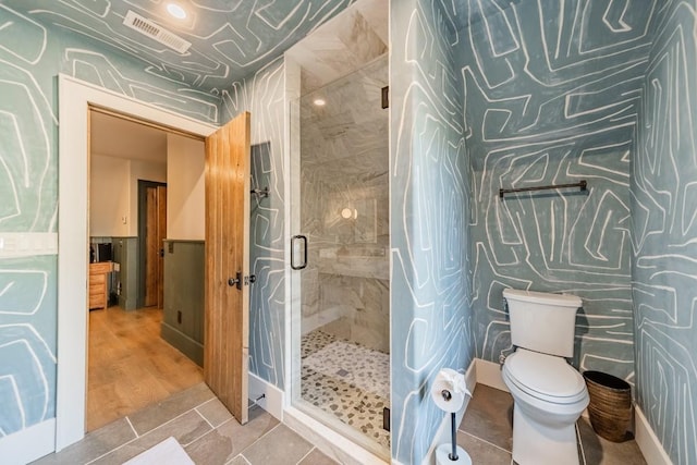 bathroom featuring toilet, a shower stall, visible vents, and tile patterned floors