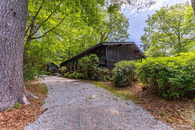 view of side of home with a sunroom and driveway